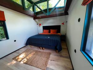 ein Schlafzimmer in einem Minihaus mit einem Bett darin in der Unterkunft 0'Bama - Unique Upcycled Tiny House in Selgas