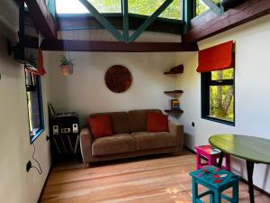ein Wohnzimmer mit Sofa und Tisch in der Unterkunft 0'Bama - Unique Upcycled Tiny House in Selgas