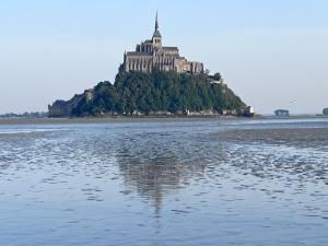 an island in the water with a large building on it at L'escapade Saint Michel in Val Couesnon