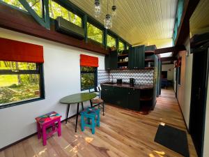eine Küche mit bunten Hockern und einem Tisch in einem Zimmer in der Unterkunft 0'Bama - Unique Upcycled Tiny House in Selgas
