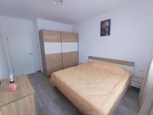 a bedroom with a bed and a wooden cabinet at AMA Home in Sebeş
