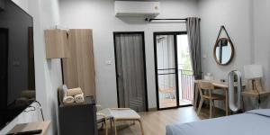 a bedroom with a bed and a table and a balcony at บ้านใต้ชุกโดน BaantaiChukadon guest house in Kanchanaburi City