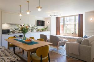 a kitchen and a living room with a table and a couch at Sigma Plus Regency Square Suites near Brighton Beach in Brighton & Hove