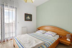 a bed with a wooden headboard in a bedroom at Les 2 tours La Rochelle in La Rochelle