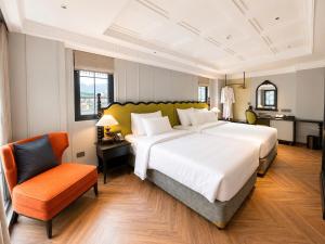 a large bedroom with a large bed and a chair at Palais De Sapa Boutique Hotel in Sapa