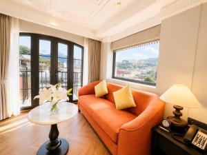 a living room with an orange couch and a table at Palais De Sapa Boutique Hotel in Sapa