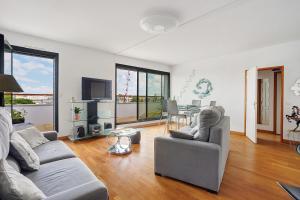 a living room with two couches and a table at Les 2 tours La Rochelle in La Rochelle