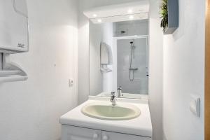 a white bathroom with a sink and a shower at Les 2 tours La Rochelle in La Rochelle +19 photos