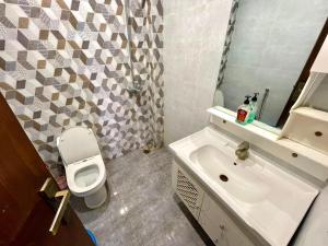 a bathroom with a toilet and a sink at 2BHK Apartment Perfect for Families & Groups in Rawalpindi