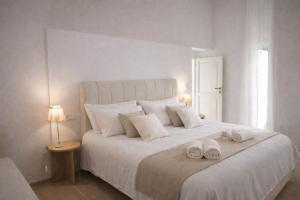 a bedroom with a large white bed with two towels on it at Locanda la Rocca Residenza d'Epoca in Fossombrone