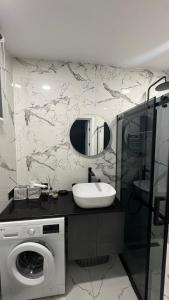 a bathroom with a sink and a washing machine at Bamboo Beach 358 in Ts'ikhisdziri