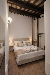 a bedroom with a large bed with towels on it at Locanda la Rocca Residenza d'Epoca in Fossombrone