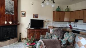a living room with a couch and a flat screen tv at Casa Rural Los Acebos II in Riópar