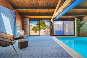 a house with a swimming pool and a wooden ceiling at Domaine Roses Des Sables in La Jarrie +30 photos