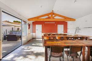 a dining room with a large wooden table and chairs at Domaine Roses Des Sables in La Jarrie