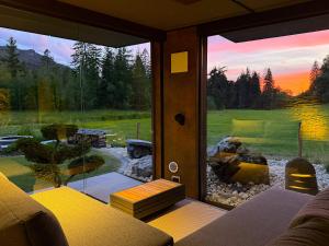 a living room with a large window looking out at a yard at ALPENGARTEN EIGENTHAL - Private Wellness Retreat in Eigenthal
