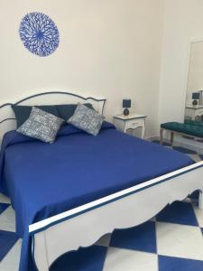 a bed with blue sheets and pillows in a bedroom at Dimora Patrizia in Scario
