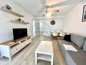 a living room with a couch and a tv at Beach Formentor salou in Salou