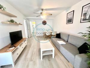 a living room with a couch and a tv at Beach Formentor salou in Salou