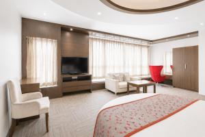 a hotel room with a bed and a living room at Viz Park Hotel - Business Hotel & Banquet, GIDC Anand in Anand