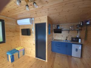 a kitchen in a wooden cabin with a sink at Hill House Merisi in Merisi +21 photos