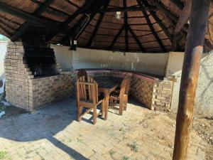 a patio with a table and two chairs under a roof at Ave Maria Camping site in Welkom