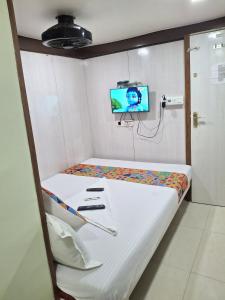 a hospital room with a bed and a tv at Venus Guest House in Mumbai