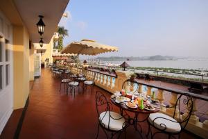 a restaurant with tables and chairs and a view of the water at Victoria Chau Doc Hotel in Chau Doc
