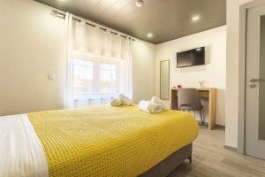 a bedroom with a yellow bed with towels on it at Flôr do Távora in Vila da Ponte