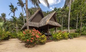 a small hut with a thatched roof on a beach at Cauayan Boutique Private Island - formerly Cauayan Island Resort in El Nido