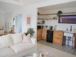 ein Wohnzimmer mit weißem Sofa und eine Küche in der Unterkunft Lemon Tree Studio in Beechworth