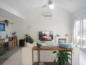 ein Wohnzimmer mit einem Tisch und einem Fernseher in der Unterkunft Lemon Tree Studio in Beechworth