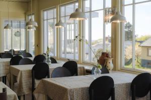 a dining room with tables and chairs and windows at Hotel Villa Lejet in Tisvilde +25 photos