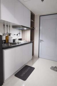 a kitchen with white cabinets and a white door at Jtower residences mandaue 12th flr in Mandaue City