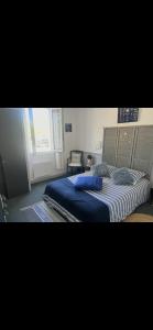 a bedroom with a bed with blue sheets and a window at Chambre la paix lot in Payrac