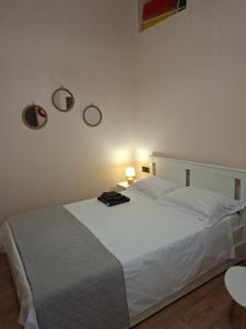 a bedroom with a white bed and two mirrors on the wall at Mare e Vita in Patitiri