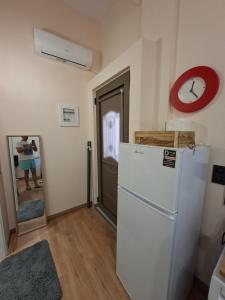 a kitchen with a refrigerator and a clock on the wall at Mare e Vita in Patitiri +6 photos