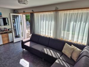 a living room with a couch and a large window at FeWo Aquileia Scuol, Gratisparken, Terrasse, Wifi, flexible Zimmerwahl, Familien in Scuol