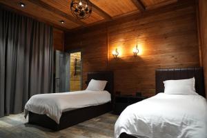 two beds in a room with wooden walls at Fayz Mount Residence in Chimgan +52 photos