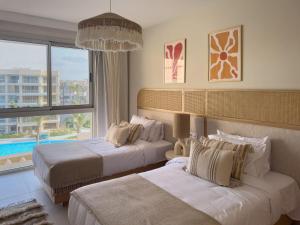 a hotel room with two beds and a large window at Marassi Marina Views At BirdNest in Sīdī ‘Abd ar Raḩmān +231 photos