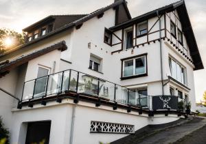 a white house with a balcony at Appartement - Eifelglück in Pelm