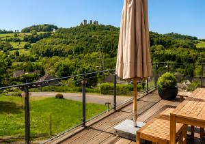 an umbrella on a deck with a view of a hill at Appartement - Eifelglück in Pelm