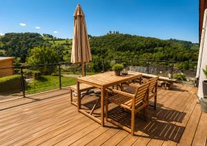 a wooden deck with a table and an umbrella at Appartement - Eifelglück in Pelm