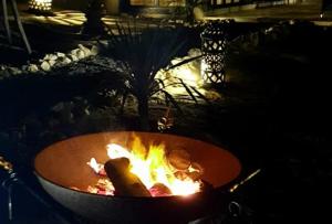 a fire pit with food cooking in it at night at TigerLounge in Douaïra