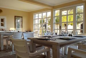 a dining room with a table and chairs and windows at TigerLounge in Douaïra