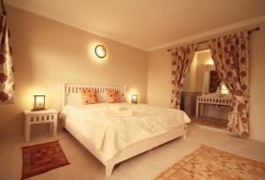 a bedroom with a white bed and a window at TigerLounge in Douaïra