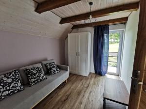 a living room with a couch and a large window at Domki Jaśmin 781-012-181 in Polańczyk