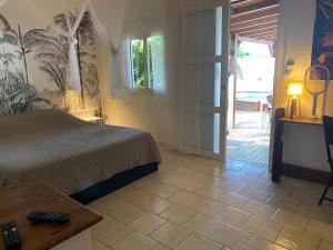 a bedroom with a bed and a door to a patio at MANGOBELO entre océan et rivières in Capesterre-Belle-Eau +42 photos