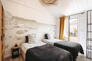 two beds in a room with a mural on the wall at Domaine Roses Des Sables in La Jarrie