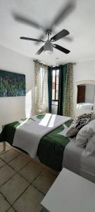 a bedroom with a large bed with a ceiling fan at Apartamento playero Privado WiFi- MorroJable in Morro del Jable